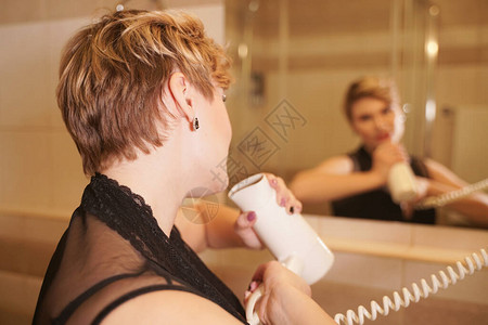 在镜子旁边的浴室洗完头发后喜悦的雌在图片