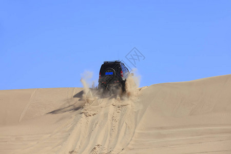 一辆越野车在沙漠中行驶图片