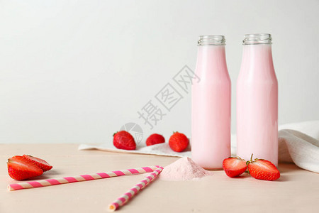 白桌上的草莓蛋白奶昔瓶图片