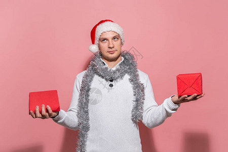 穿着白色毛衣和红色圣诞帽的汉森男子正在选择要赠送的圣诞礼物圣诞节和图片