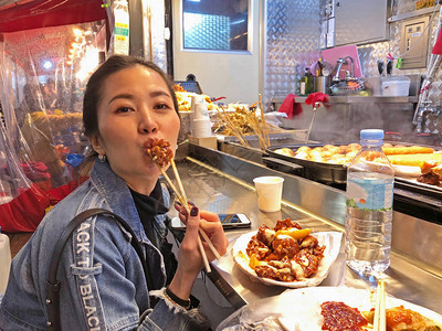 在韩国首尔吃炸鸡街食品的年轻女图片