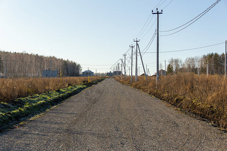 俄罗斯套娃,村庄里有电线杆的土路秋天阳光明媚背景
