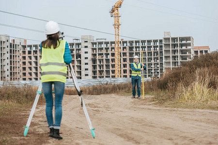 测量泥土路上土地的测量员建筑图片