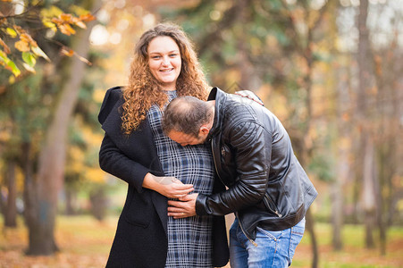 秋天背景中的幸福怀孕夫妇图片