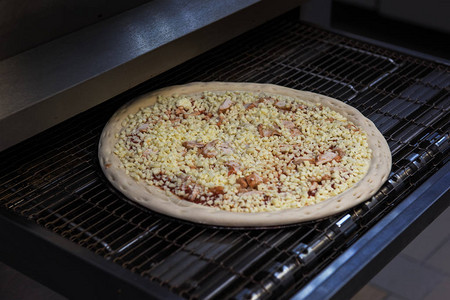 在餐厅厨房的烤箱里准备披萨图片