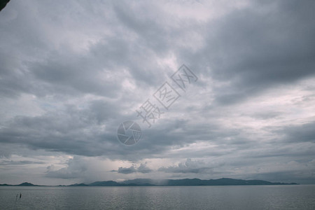 海洋中乌云密布的天空和岛上的雨热带岛屿上空阴沉多雨的天气景观图片