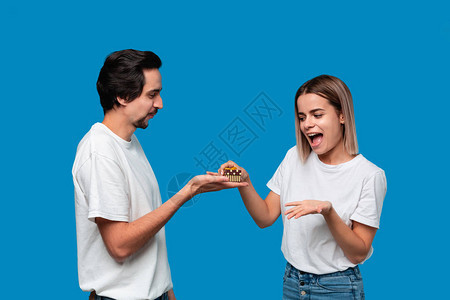 男朋友给他的女朋友送礼物在蓝色背景中被隔图片