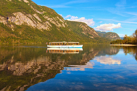 渤兴湖上的旧旅游船Bohinj湖全景与反映在绿松石水中的山脉的浪漫而宁静的场景湖图片