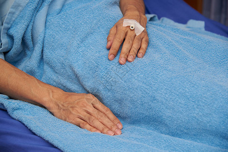 一名男病人躺在医院床上有肝素锁左手图片