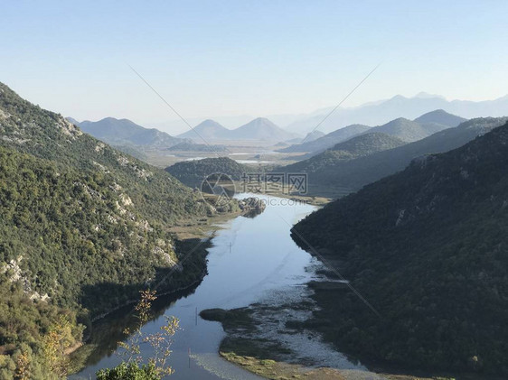 白天森林覆盖的山区之间河流的闪光景色图片