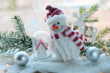 玩具雪人房子圣诞装饰窗户背景的木质表面上的照明为冬季节图片