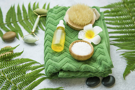 Spa仍以freangipani花朵体积刷子油瓶浴盐毛巾按摩石和绿叶健康及图片