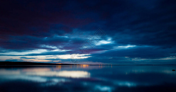 夜空和大海夕阳和平静的水与云彩的日落天空图片