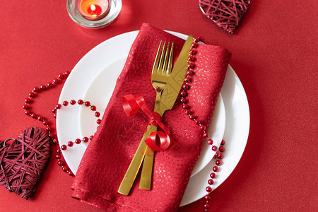 餐桌上配有叉子刀餐巾和情人节心形装饰在情人节的红色图片