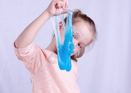 可爱的小女孩拿着黏液玩具全世界流行的自制玩具孩子用粘液图片