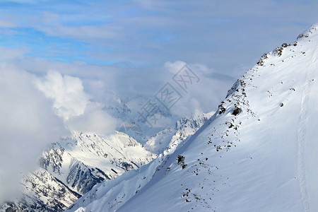 在云彩蓝天的雪山峰顶图片