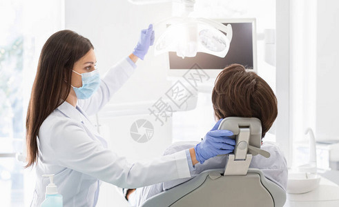 戴面罩的女牙医在治疗病图片