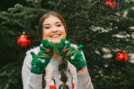 喜悦的年轻快乐女人的喜悦肖像站在圣诞树旁图片