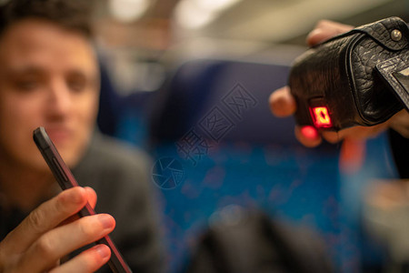 年轻有同情心的男人在火车上展示了一个电子售票员在你的智能手机上通过图片