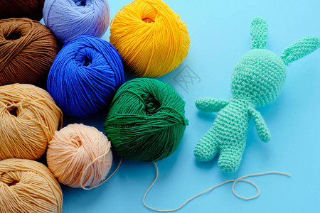 蓝色背景上有浅色的线纹胸和面糊绿毛兔关于Amigurumi玩具制作手工艺编织图片