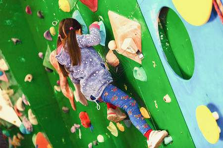 带攀岩墙的休闲公园里的小女孩登山者背景图片