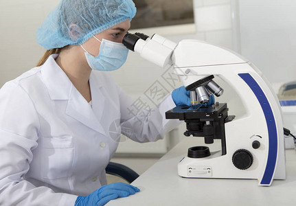 医务人员在显微镜中观察并分析材料现代化验室和图片