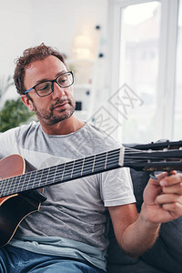 男人在客厅里弹吉他图片