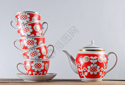 将古董陶瓷杯和茶壶堆在木制图片