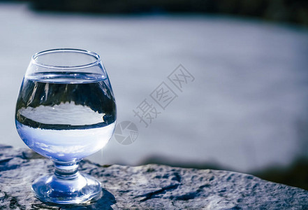 美丽的湖底有纯净水的白兰地杯子有选择焦点图片