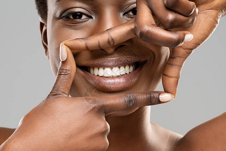 构筑你的笑容美丽的非洲女人用手指勾勒出完美图片