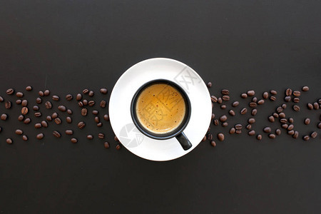 黑桌上的热浓缩咖啡和咖啡豆图片