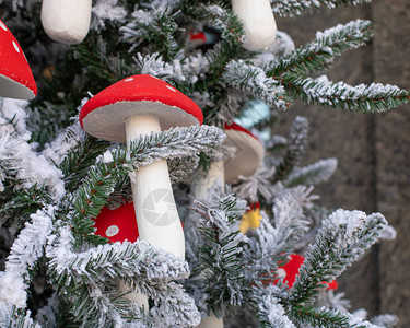 人造蘑菇鹅膏菌装饰圣诞树带红色帽子特写的鹅膏菌一棵人造圣诞树的图片