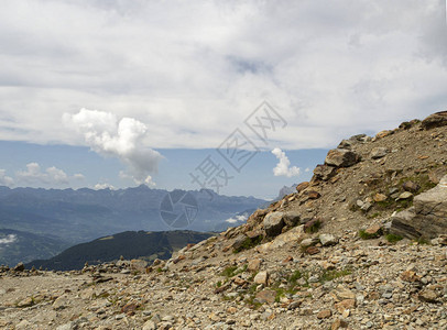 山地景观斜坡上有很多石头在下方很远的地方可以看到山脉山上的单云图片