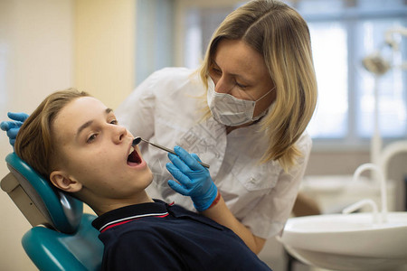 牙医女生在诊所的牙科椅上对男人图片