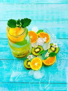 脱毒水鸡尾酒健康饮用与冰和橙色在蓝图片
