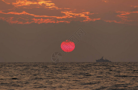 日落海滩背景海浪在傍晚日落的光线下太阳在地平线以下在海的地平线上图片