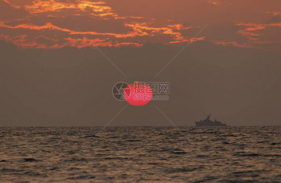 日落海滩背景海浪在傍晚日落的光线下太阳在地平线以下在海的地平线上图片