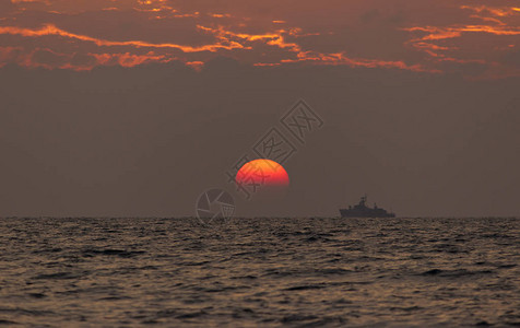 日落海滩背景海浪在傍晚日落的光线下太阳在地平线以下在海的地平线上图片