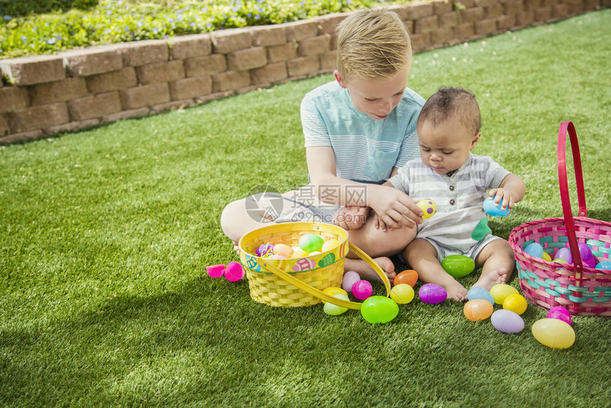 两个可爱的小男孩在院子里户外寻找复活节彩蛋时收集鸡蛋一起工作把鸡蛋放在图片