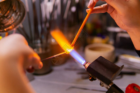 制作beadmaking使用高温燃烧器在玻璃吹泡车间用刮线方法手图片