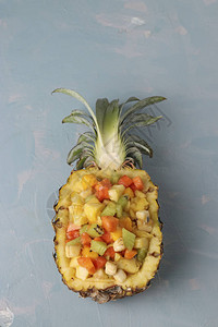 菠萝中的热带水果沙拉在浅蓝色背景特查顶视图片