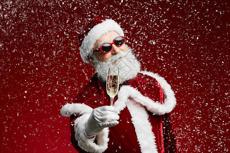 酷圣诞老人拿着香槟酒杯的腰部肖像图片