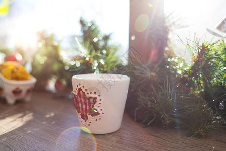窗台上有圣诞装饰品的杯子装饰圣诞树分支庆祝寒假用云杉枝装饰窗户为新图片