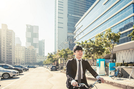 商人骑自行车上午在城市街道上工作背景图片