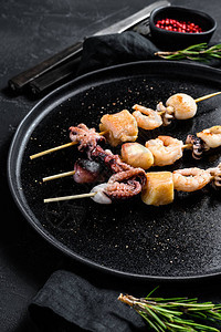 海产食品烧烤虾章鱼鱿鱼和贝类的木柴烤肉黑色背图片