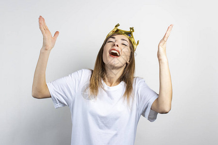 尖叫王头戴王冠的年轻女子在浅色背景下情绪激动和庆祝背景