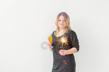 节日圣诞节生日和新年概念妇女庆祝并盛装酒杯和闪光灯图片