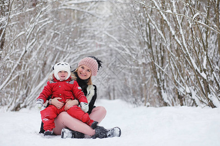带着孩子的年轻家庭正在冬季公园散步父母带着孩子的冬天散步在冬天的图片