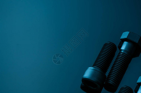 蓝色背景上的金属螺栓五金工具特写六角头螺栓和带复制空间的内六角螺栓汽车工程中使用的螺纹紧固件六角螺栓高图片