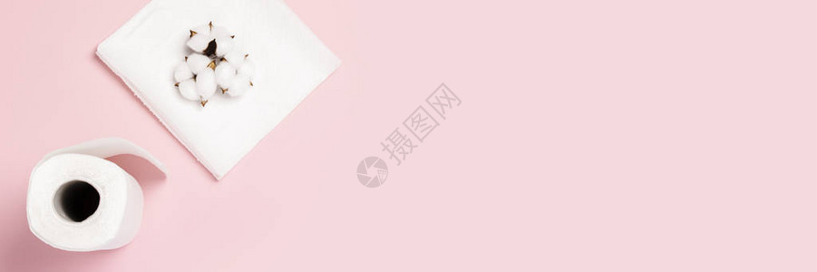 粉红色背景的纸巾和棉花卷概念是100种精细柔软的天然产品平坦的躺着图片